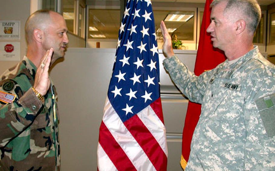 Brig. Gen. Sean Byrne, the Army’s director of personnel management, right, swears in Sgt. Maj. Terry Grezlik, the first soldier to make the reserve-to-active switch under the Army’s new policy.