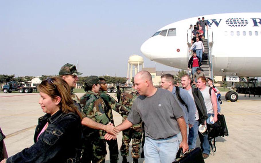 Airmen assigned to the 8th Fighter Wing are welcomed to Kunsan Air Base, South Korea, in May 2004 as they step off the Patriot Express, a commercial flight chartered by the U.S. military.