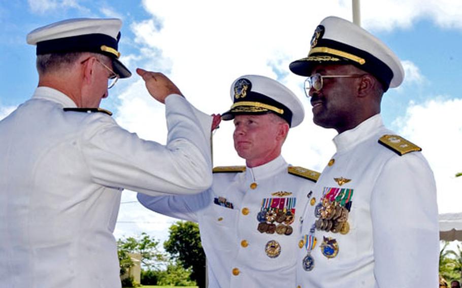 Rear Adm. Christopher E. Weaver, left, commander of Navy Installations Command, returns a salute by Rear Adm. Charles J. Leidig Jr. to signify assumption of command of U.S. Naval Forces Marianas. They are joined by Rear Adm. Arthur J. Johnson, outgoing commander.