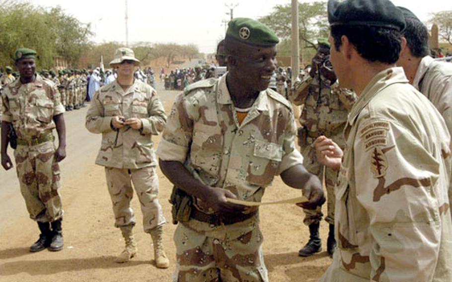 A Nigerien soldier accepts a certificate during a ceremony in downtown Tahoua, Niger, on June 22 that signaled his soldiers' completion of two weeks of training by U.S. Green Berets.