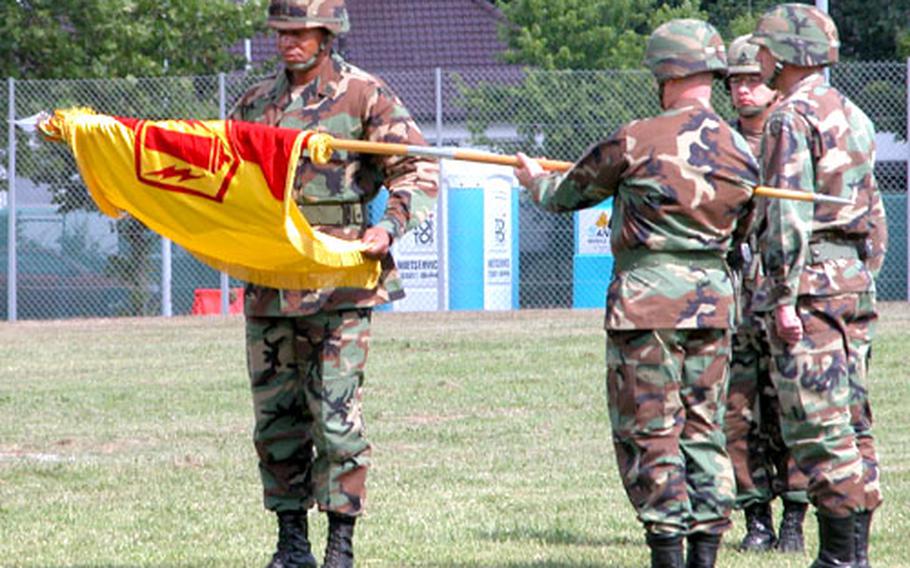 Command Sgt. Maj. Michael Pinckney begins to furl the 41st Field Artillery Brigade flag, to be cased during the inactivation ceremony on the post soccer field in Babenhausen, Germany, Thursday.