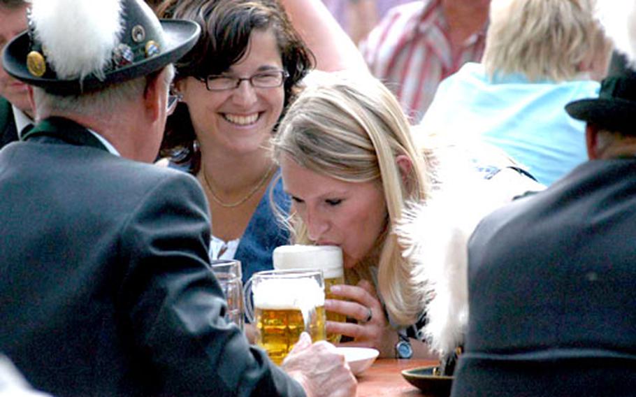 Grafenwöhr resident Katja Dumler, center, vacuums the top off her brew, much to the amusement of fellow local resident Verena Schüller.
