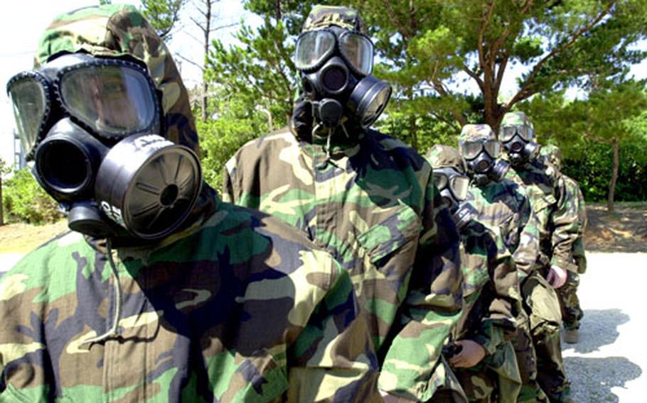 Servicemembers from 3rd Medical Battalion stand ready to enter the "gas chamber" Friday on Camp Hansen, Okinawa. More than 230 sailors and Marines were participating in Solar Challenge, a weeklong exercise that allowed 3rd Medical Battalion personnel to refresh their war-fighting skills.