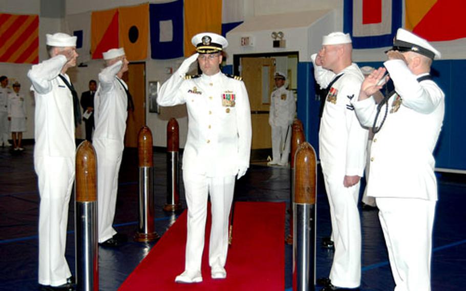 Cmdr. Randall H. Martin is “piped aboard” during a change-of-command ceremony Friday at which he replaced Cmdr. Francis X. Martin as base commander for Chinhae Naval Base, South Korea.