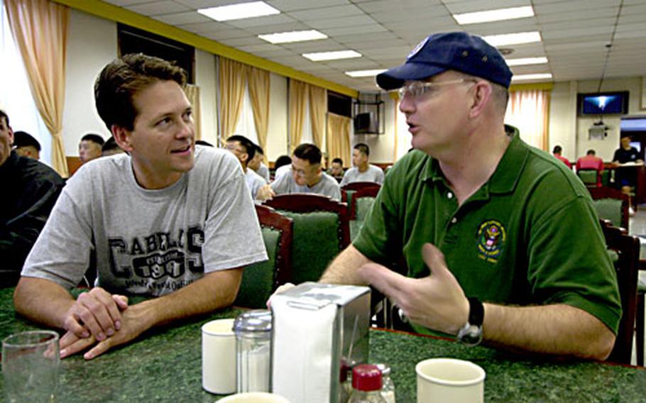 Country recording artist Ty England, left, and Area II commander Col. Timothy McNulty talk Sunday during a visit to the dining facility on Yongsan Garrison, South Korea.