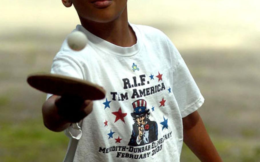 Osaze Anyabwile, 8, keeps his eyes on the ball as he juggles it on his racket during outdoor games at Dragons, Dreams and Daring Deeds in Giessen, Germany, part of the 284th Base Support Battalion’s summer reading program.