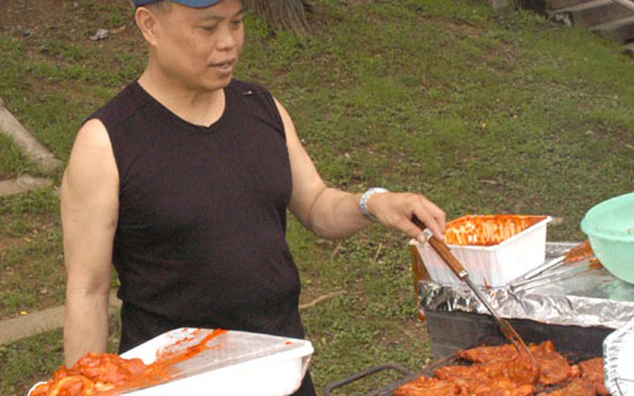 Chief Warrant Officer Atelano Villon mans the grill at his retirement picnic Tuesday at Yongsan Garrison, South Korea.