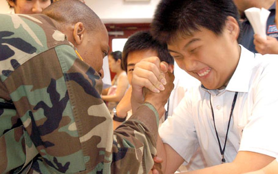 Sgt. Robert E. Owens Jr., with the U.N. Command, Military Armistice Commission at Camp Bonifas, arm-wrestles a South Korean high school student Wednesday in Seoul during the USO Good Neighbor Program.