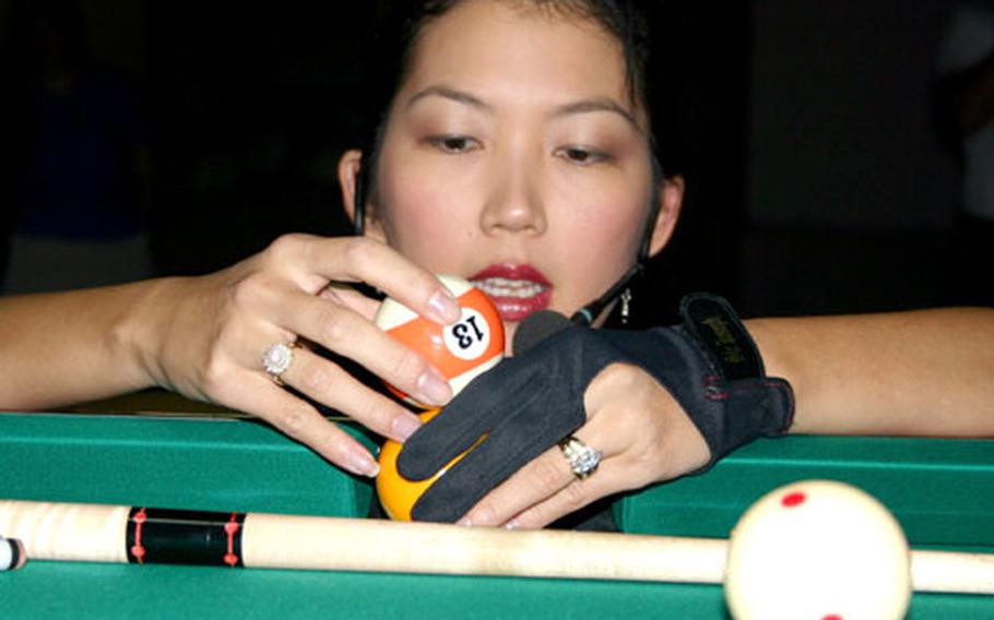 Jeanette Lee stacks pool balls for a trick shot she calls "the railroad."