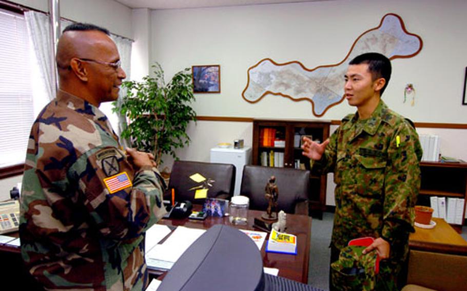 First Sgt. Eugene Moses, left, talks to Sgt. Yoshiaki Sato last week at Camp Zama, Japan, as Sato begins his participation in the USAR-J-Ground Staff Office Cooperative Work Program.