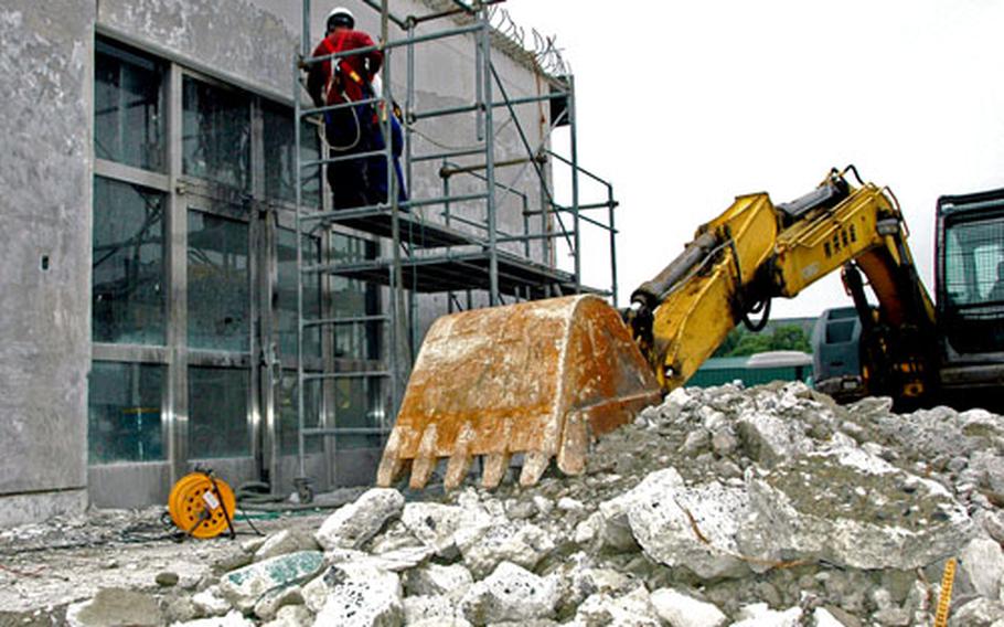Construction workers demolish the front entrance of the Showboat Theater at Sasebo Naval Base on Monday in preparation for a $300,000 expansion and renovation designed to create more snack bar space and a more efficient flow for ticket purchases.