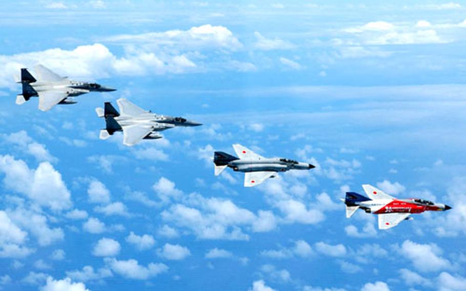 A formation of 67th Fighter Squadron F-15 and Japan Air Self-Defense Force F-4 aircraft fly over Okinawa after a joint training mission that tested the air defense and counter-capabilities of both countries.