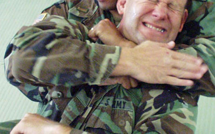 Lt. Col. Jody Hicks taps out Tuesday, letting 2nd Lt. Christopher Casper know that he can ease up on his choke hold during "combatives" training at Mannheim, Germany.