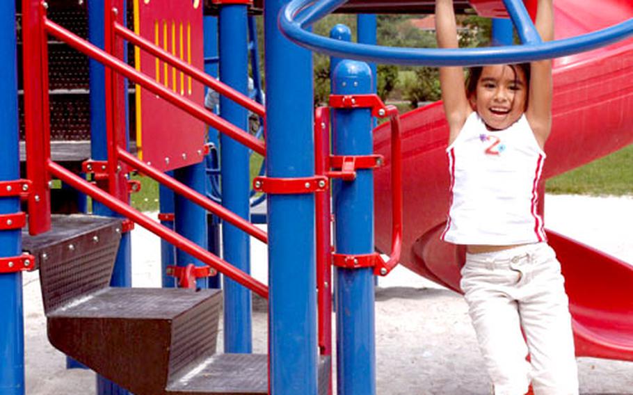 Six-year-old McKenna Luna takes advantage of some of the remaining playground equipment Tuesday in Vilseck, Germany. The base was one of three in the 100th Area Support Group, along with Hohenfels and Grafenwöhr, to recently find that some of its school and community playground equipment was contaminated with lead-based paint.