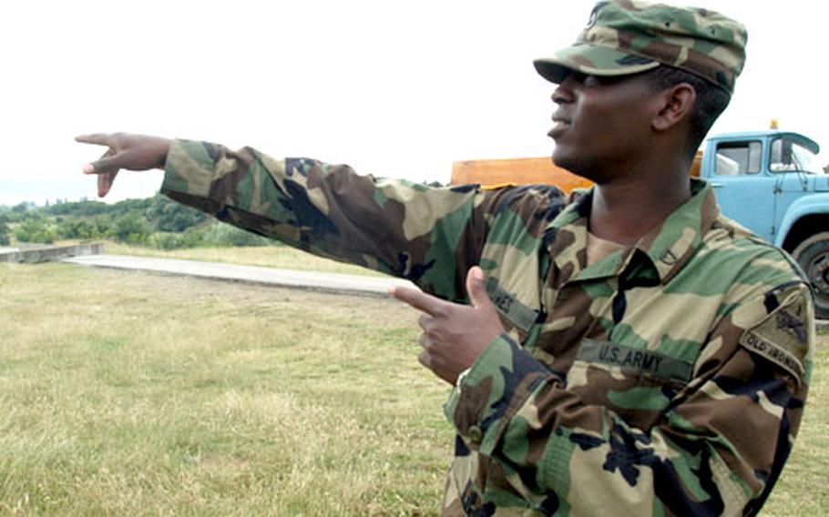 Pfc. Jeremy James points to the area where he stopped a runaway horse and cart that were headed for the front gate to Novo Selo Training Area, Bulgaria.