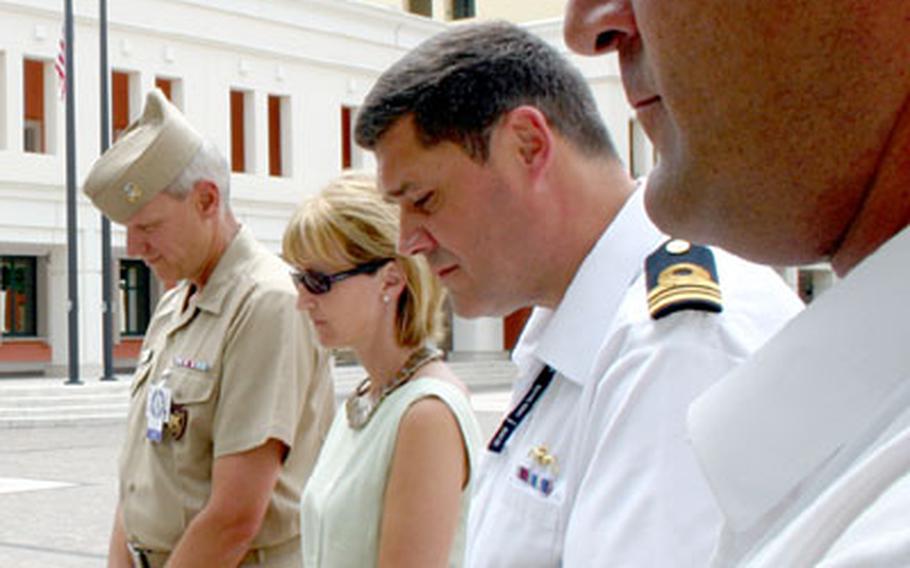 Lt. Cmdr. Sam Toothill, far right, and Lt. Cmdr. Charlie Neve, center, both submariners with the British Royal Navy, participated in the observance of a moment of silence for victims of the London bombings Thursday at Naval Support Activity Naples, Italy.