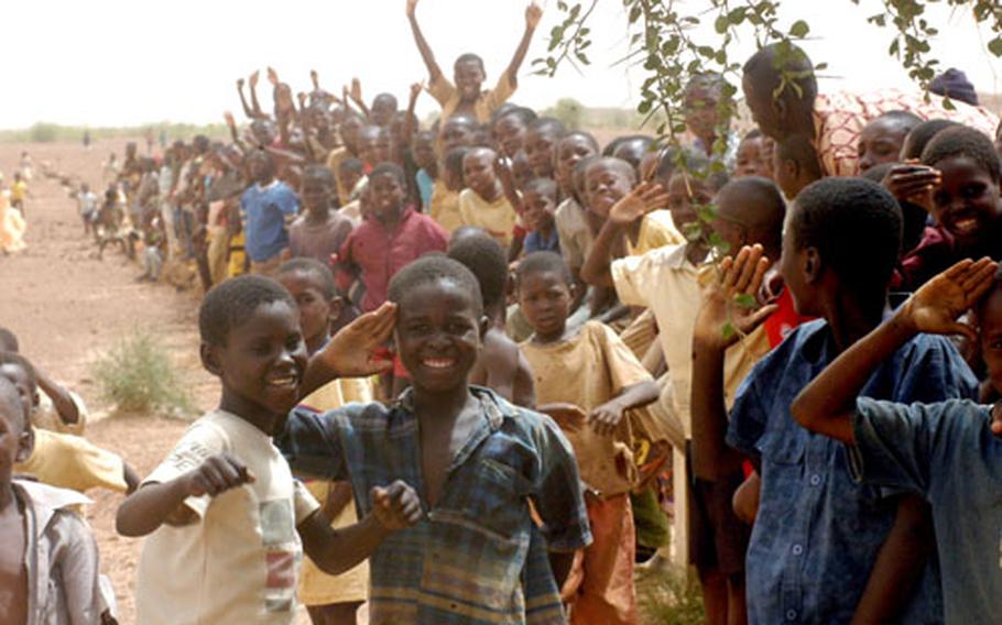 Children at an airstrip outside Tahoua, Niger, gather to watch a C-17 carrying U.S. soldiers take off. The Europe-based soldiers had just finished a training mission as part of Flintlock 05 in June.