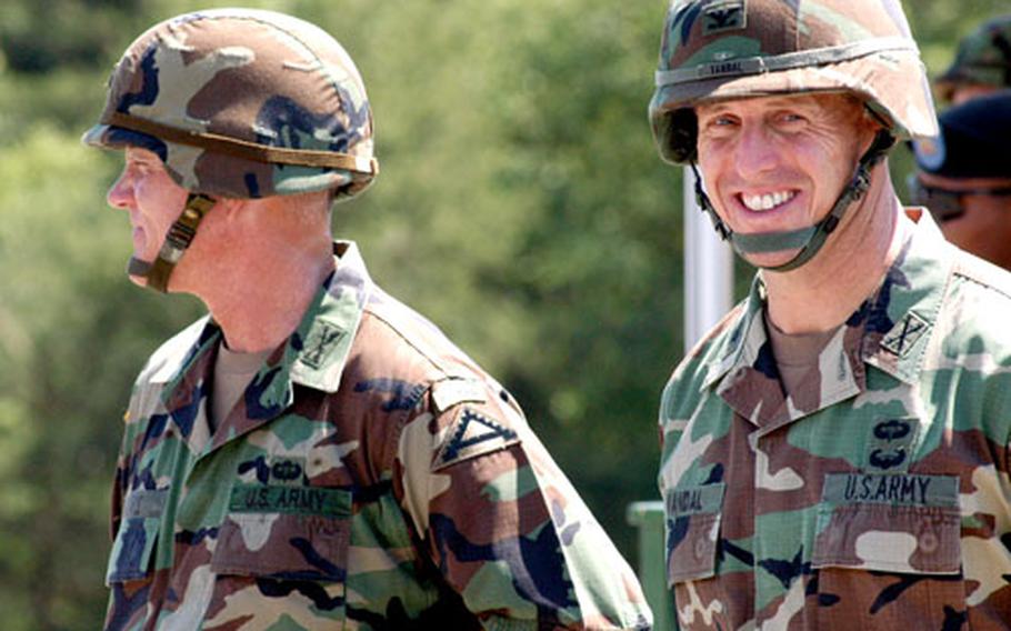 Col. Thomas Vandal, right, smiles at the crowd just before the start of the Friday afternoon ceremony to formally make him the commander of the operations group at the Combat Maneuver Training Center in Hohenfels, Germany. Vandal is taking the reins from outgoing Col. Mike Davis, left.