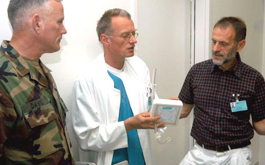Dr. Thomas Bein, center, and Philipp Alois, right, co-inventors of the Novalung internventional lung assist, talk recently in Regensburg, Germany, with Col. Mike Davis, then-commander of the operations group for the Combat Maneuver Training Center in Hohenfels.