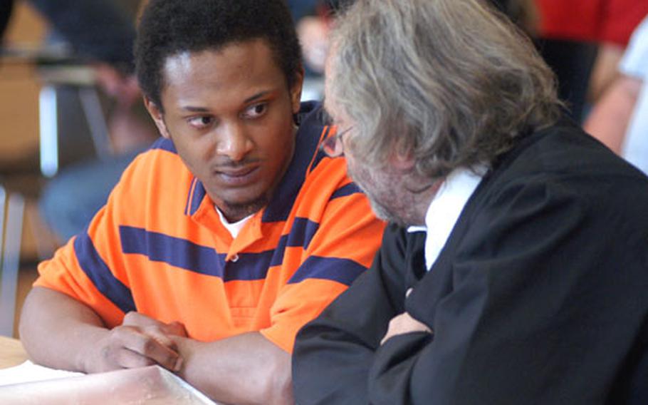 Vada Rucker talks to his attorney, Norman Jacob, before his trial continued Wednesday morning in Würzburg, Germany.
