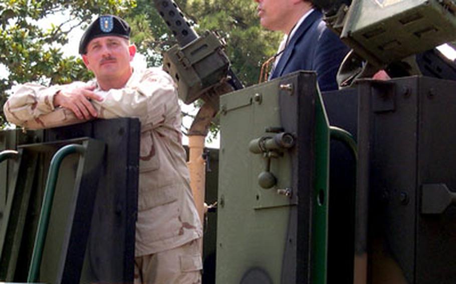 First Lt. James McCormick, left, a member of the 518th Combat Gun Truck Company, pauses onboard a modified 5-ton truck on display near the Capitol in Washington on Thursday.