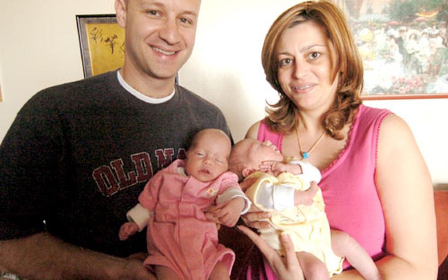 Chief Petty Officer Clay Sakellaris and his wife, Niki Tsouchlaraki, hold their twin babies, Emma Eve and Harisia Sakellaris, born July 1.
