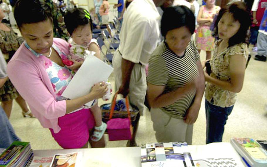 Base residents take a look at the various programs offered by the Army Community Service Friday at Yongsan Garrison.
