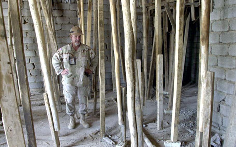 Tom Semotuk, an Army Corps of Engineers project manager, takes a look at wooden poles temporarily supporting the roof of an Iraqi Special Forces barracks under construction near Baghdad.