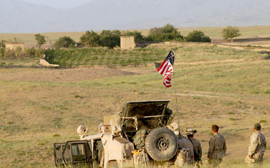 Soldiers from Company A, 2nd Battalion (Airborne), 503rd Infantry Regiment look from their hilltop patrol base toward a village in Afghanistan’s Surri District as they set up defenses for the night. Intelligence later said that Taliban fighters moved a machine gun into the village, which was less than 1,000 yards away, to attack the small group of troops on the hill.