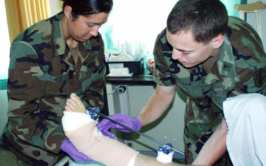 Cadet Sara Hess, left, assists 1st Lt. Parker Hahn in bandaging a patient’s wound Friday at Landstuhl Regional Medical Center. Hess, who will be a senior at Radford University’s School of Nursing in Virginia and is also in ROTC, will work at Landstuhl for four weeks as part of the Army’s nurse summer training program.