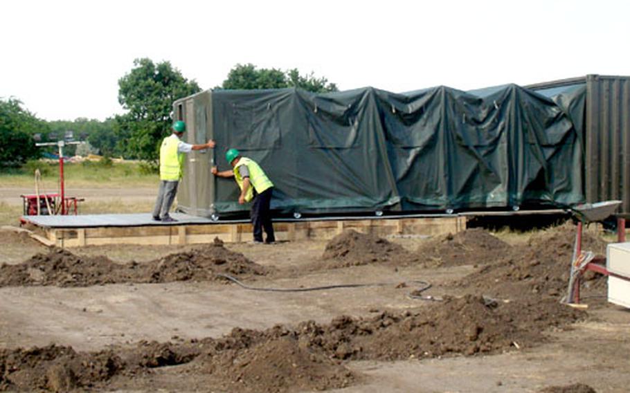 Workers roll out a tent at a temporary training base in Romania. The tents, which are about 1,300 square feet in size, fold into trailers for quick setup and breakown.