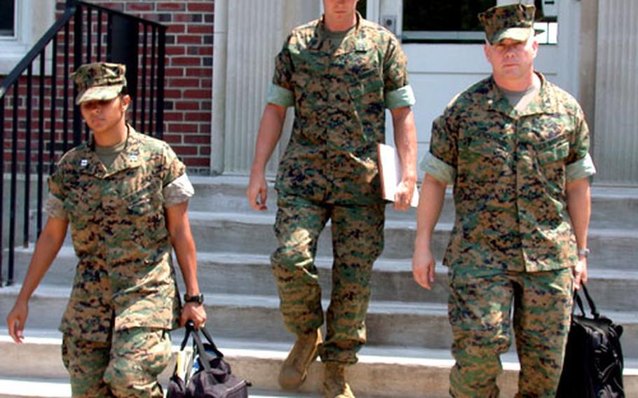 Marine Staff Sgt. Christopher R. VanGoethem, center, and his legal team — Marine Maj. Phillip Stackhouse, right, and Capt. Paula McNair — leave a Quantico, Va., courtroom Tuesday after testimony in VanGoethem's Article 32 hearing.