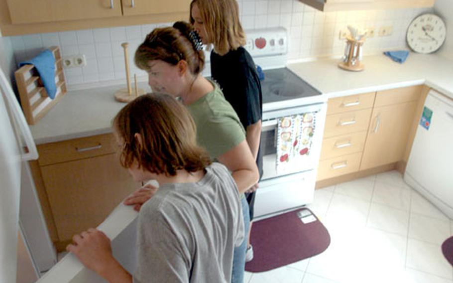 Dylan, Kathy and Brandon Provecal, front to back, check out the refrigerator during an open house Wednesday at Patch Barracks in Stuttgart, Germany. Kathy Provencal, wife of Air Force Lt. Col. Brad Provencal of the U.S. European Command, and their sons were among the guests touring the renovated Kefurt and Craig Army Family Housing facilities.