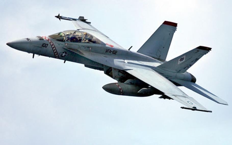 Capt. Joseph Aucoin, commander of Carrier Air Wing Five, conducts a fly-by in an F/A-18F Super Hornet from Strike Fighter Squadron 102 during a fly-over change of command above the USS Kitty Hawk on Tuesday.