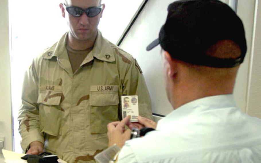 A Pond security guard at Landstuhl Regional Medical Center, Germany, checks the identification card of Pfc. Anthony Adams on Thursday. A minimum of two guards will be stationed at each of the eight entry points into the hospital starting Monday.