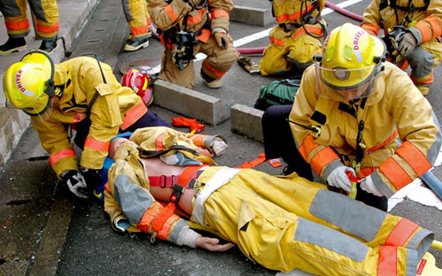 Firefighters from the Sasebo Naval Base detachment of the Commander U.S. Naval Forces Japan Regional Fire Department take part in a full-blown exercise in response to a mock fire at an uninhabited tower in the main base housing area Friday morning.