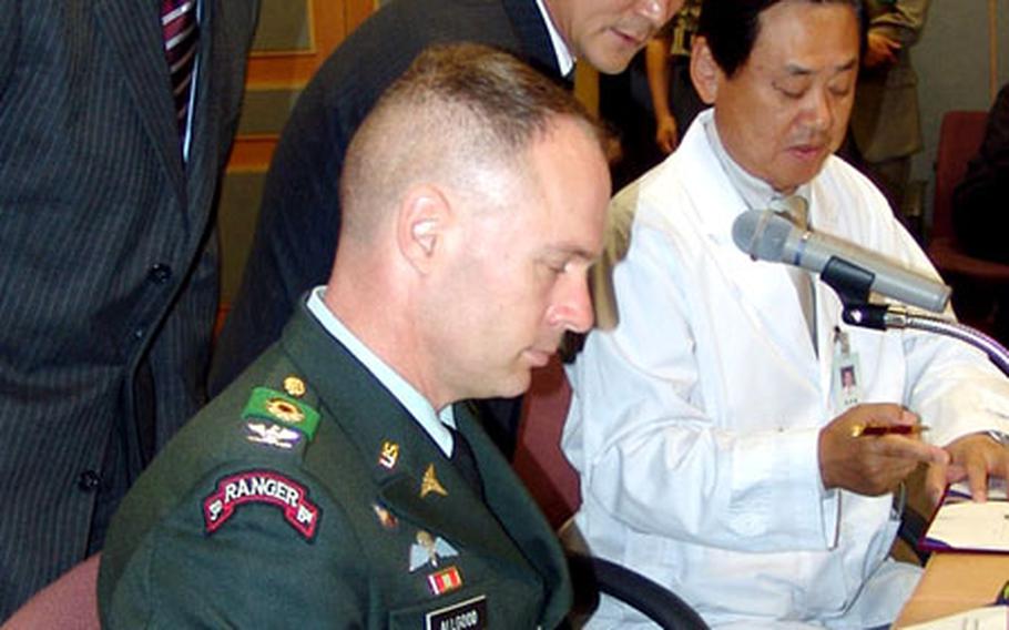 Col. Brian D. Allgood, seated in front, commander of the 18th Medical Command, South Korea, signs a health-care agreement in June with Ewha Medical Center in Seoul.