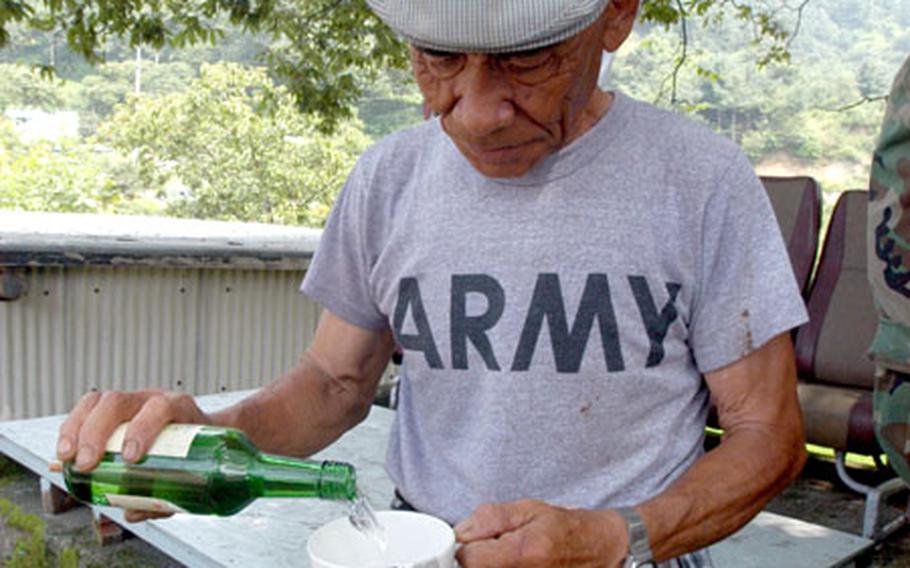 Golsandong’s oldest resident, Paek Mun-kwan, 71, pours a cup of soju, a popular South Korean alcoholic beverage.