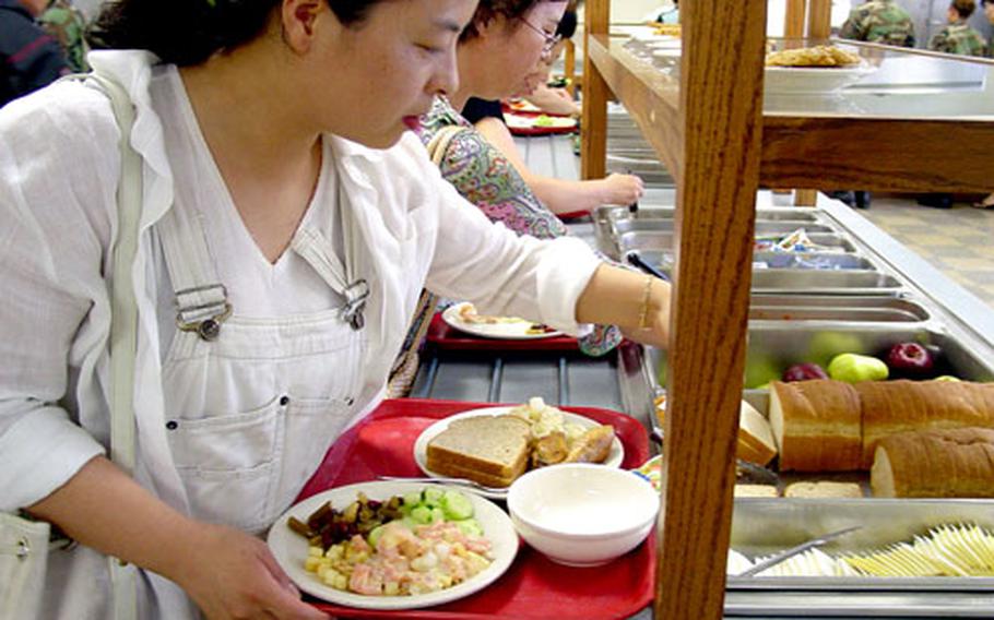 Teachers from Chilgok County sample the cuisine at the Camp Carroll dining facility. A group of 31 teachers toured the installation, visiting several facilities including barracks and the new post fitness center.