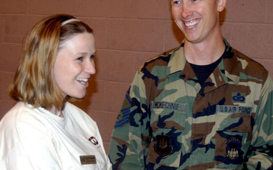 Master Sgt. John McKechnie, the readiness NCO at RAF Mildenhall, England, shares a laugh with Toni Cisneros, wife of Staff Sgt. Ricardo Cisneros of the 100th Operations Support Squadron, during a dinner for spouses of deployed troops Friday.
