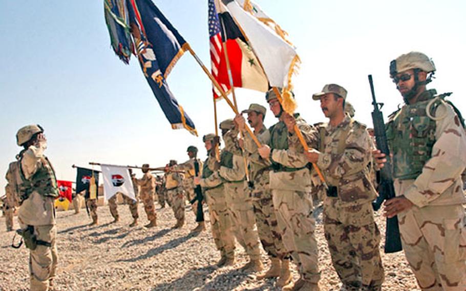 U.S. and Iraqi soldiers salute as the colors are passed during the transfer of Forward Operating Base Omaha in Tikrit, Iraq.