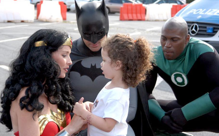 Reina Guerriero, almost four, talks to Wonder Woman as Batman and Green Lantern listen during the Darmstadt military community's National Night Out.