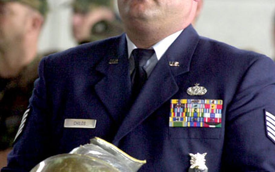 An airman holds Senior Airman Timothy Alford&#39;s firefighter&#39;s helmet during Friday&#39;s memorial at Spangdahlem Air Base.