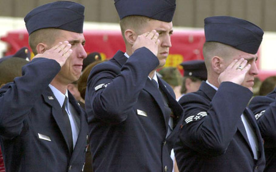 Air Force airmen salute during the playing of "Taps" in honor of Senior Airman Timothy Alford and Airman 1st Class Erik Salazar.
