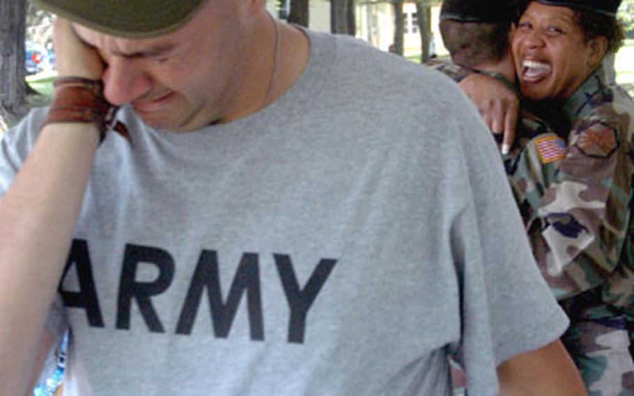 Tim Kaiser, an employee with the 6th Area Support Group's Department of Public Works, wipes away tears after saying goodbye to Col. Gwendolyn Bonéy-Harris, right, the 6th ASG'S outgoing commander, Friday at Kelley Barracks in Stuttgart, Germany.