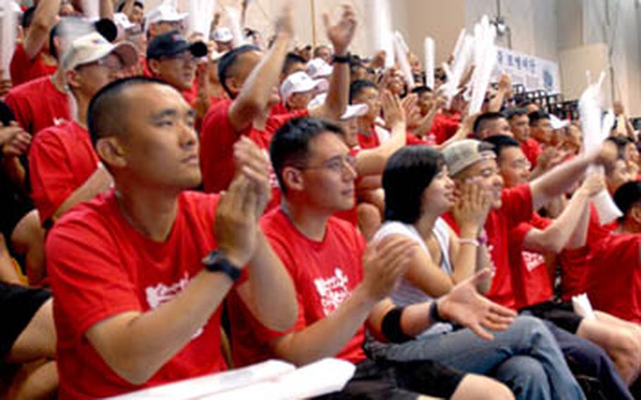 Korean Augmentees to the U.S. Army — KATUSAs — and U.S. soldiers cheer during an awards ceremony marking the end of KATUSA Friendship Week. The week promotes friendship between U.S. soldiers and KATUSAs assigned to the 2nd Infantry Division.