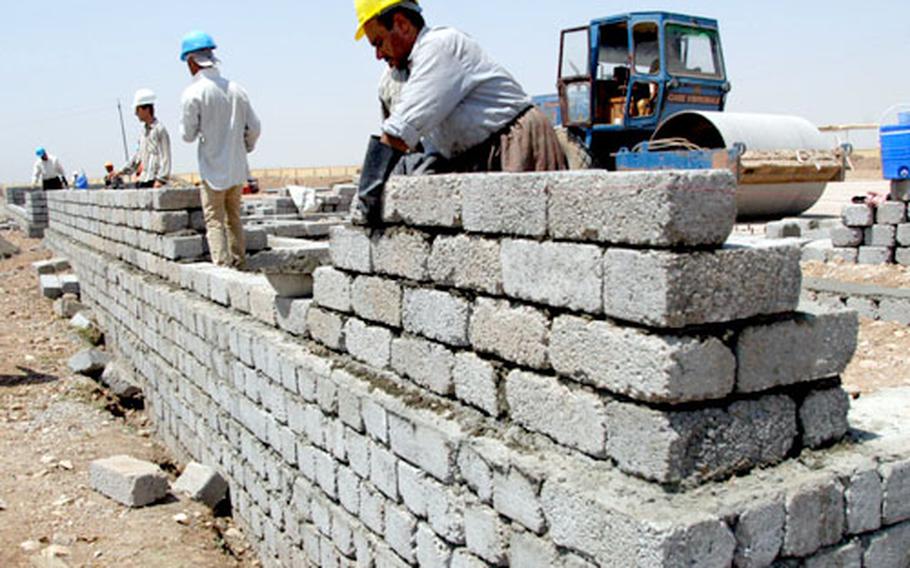 Construction workers build a wall of the Zakho Military Academy’s new gymnasium.