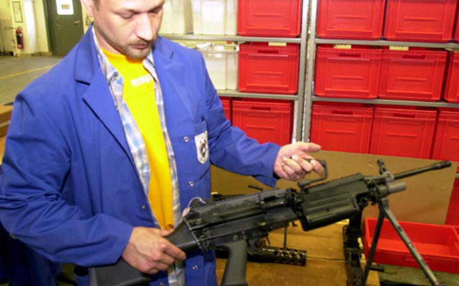 Thomas Kremers, supervisor at Maintenance Activity Mannheim, displays a squad automatic weapon that was recently refurbished.