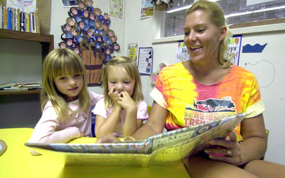 Elyse, 7, Jordan, 4, and their mother, Amy MacIsaac, look over the book “So Many Bunnies” that NCIS Federal Agent Sandy MacIsaac read to his children while being deployed to Baghdad.