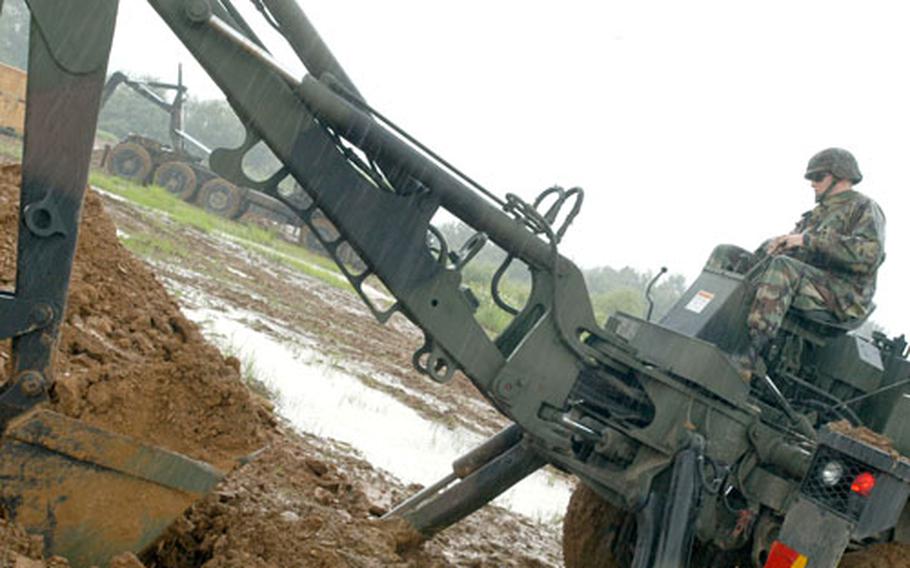 A 718th Explosive Ordinance Disposal Company soldier digs a hole to bury a Patriot missile before it is destroyed.